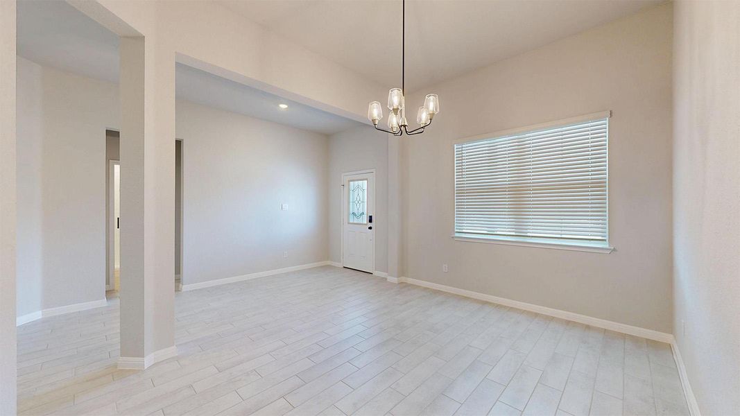Empty room featuring a chandelier and wood finish floors Empty room featuring a chandelier and wood finish floors