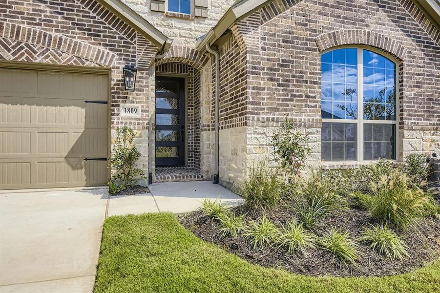 View of exterior entry featuring brick siding and stone siding
