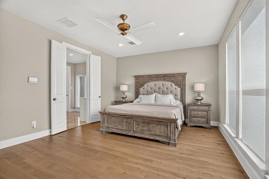 Spacious room featuring wood-finish flooring, recessed lighting, and a ceiling fan Spacious room featuring wood-finish flooring, recessed lighting, and a ceiling fan