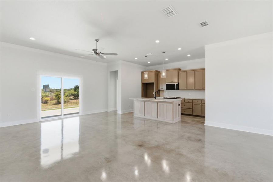 Unfurnished living room featuring ornamental molding, concrete floors, a ceiling fan, and recessed lighting