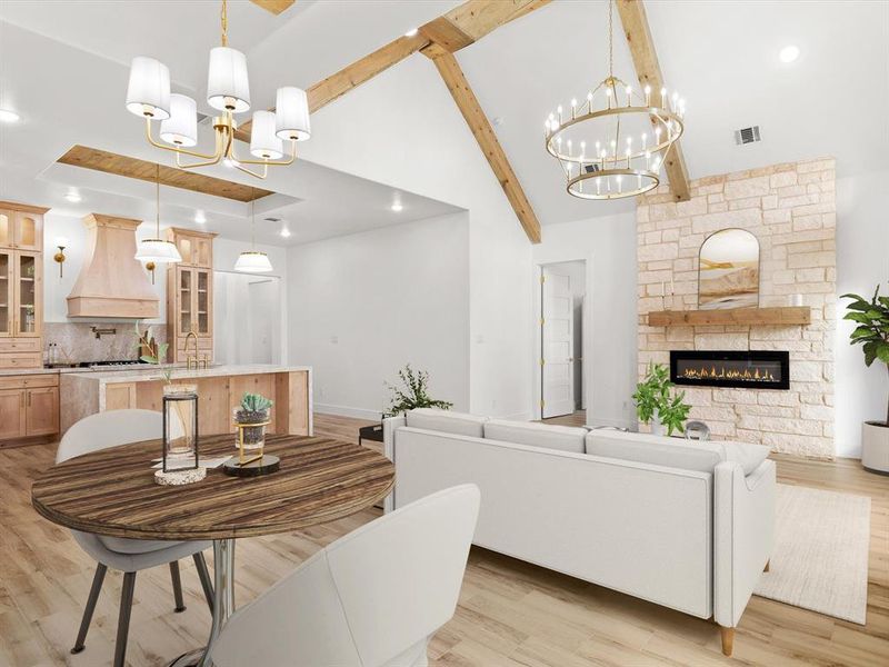 Dining space with a chandelier, a stone fireplace, recessed lighting, light wood finished floors, and beamed ceiling