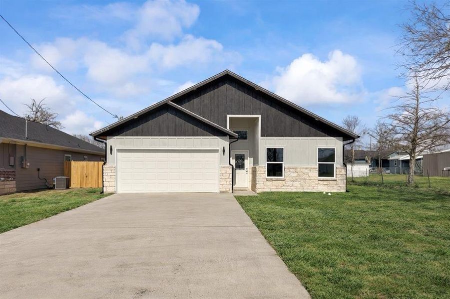 View of front of house featuring stone siding, driveway, an attached garage, and a gate View of front of house featuring stone siding, driveway, an attached garage, and a gate