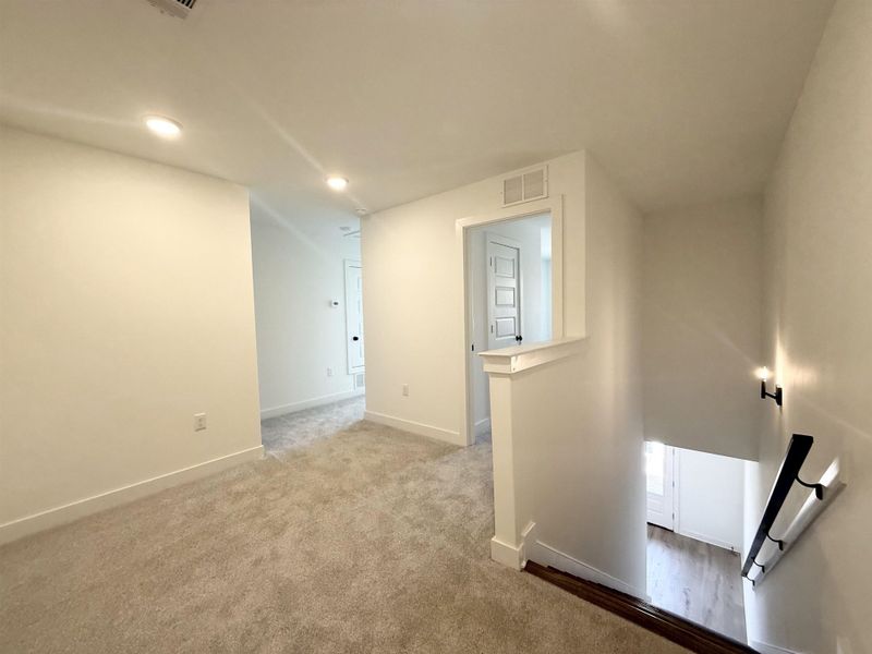 Carpeted spare room with baseboards and recessed lighting