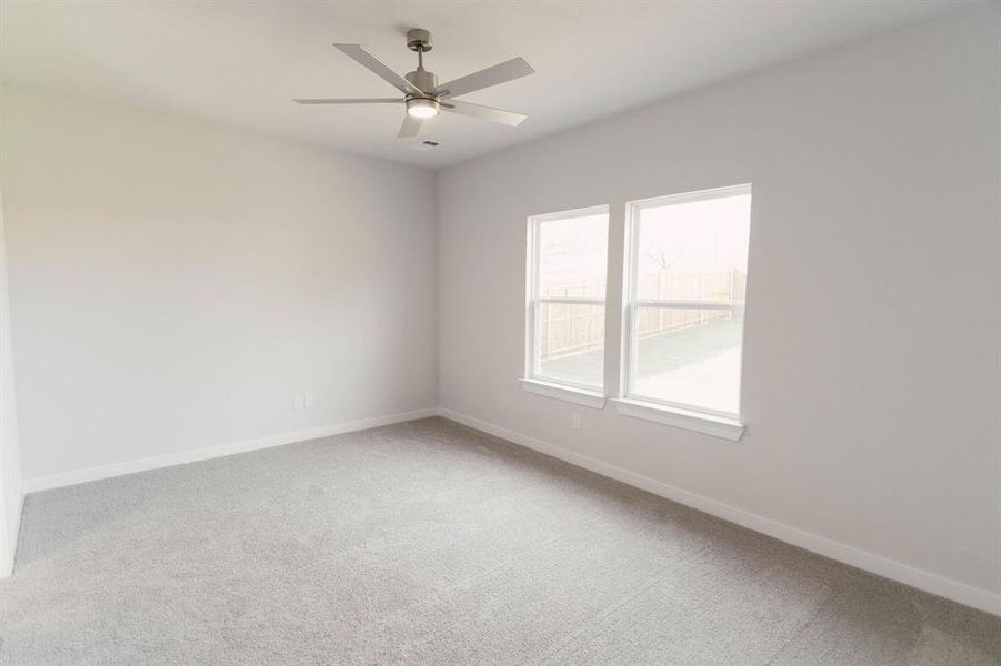 Carpeted spare room with ceiling fan