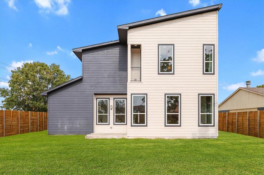 Back of property with a fenced backyard and a balcony Back of property with a fenced backyard and a balcony