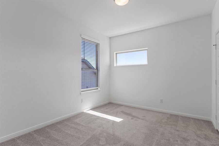 Unfurnished room featuring light colored carpet and baseboards