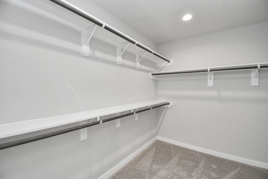 Walk-in closet that epitomizes luxury and practicality. This generously sized space features built-in shelving, offering abundant room for impeccable organization. High ceilings and recessed lighting create a bright and welcoming ambiance.