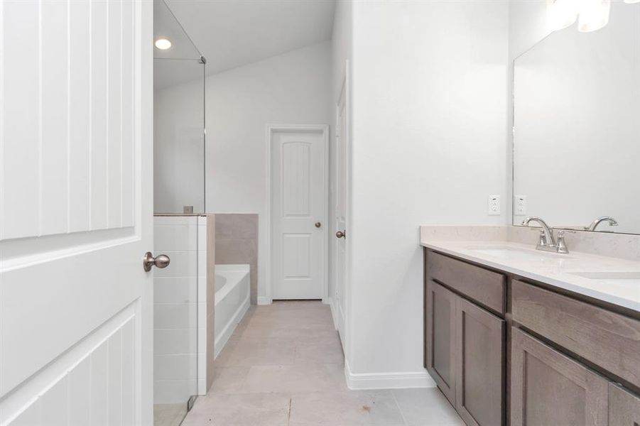 Start your day with ease in this primary bathroom featuring a double vanity with ample counter space and sleek fixtures. Perfect for morning routines, this space blends style and functionality seamlessly. **This image is from another Saratoga Home - Clover floorplan.**