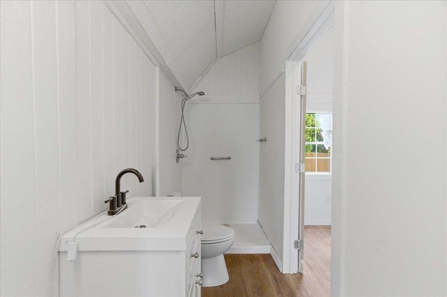 Full bathroom with single vanity stand-alone sink and stand-up shower.