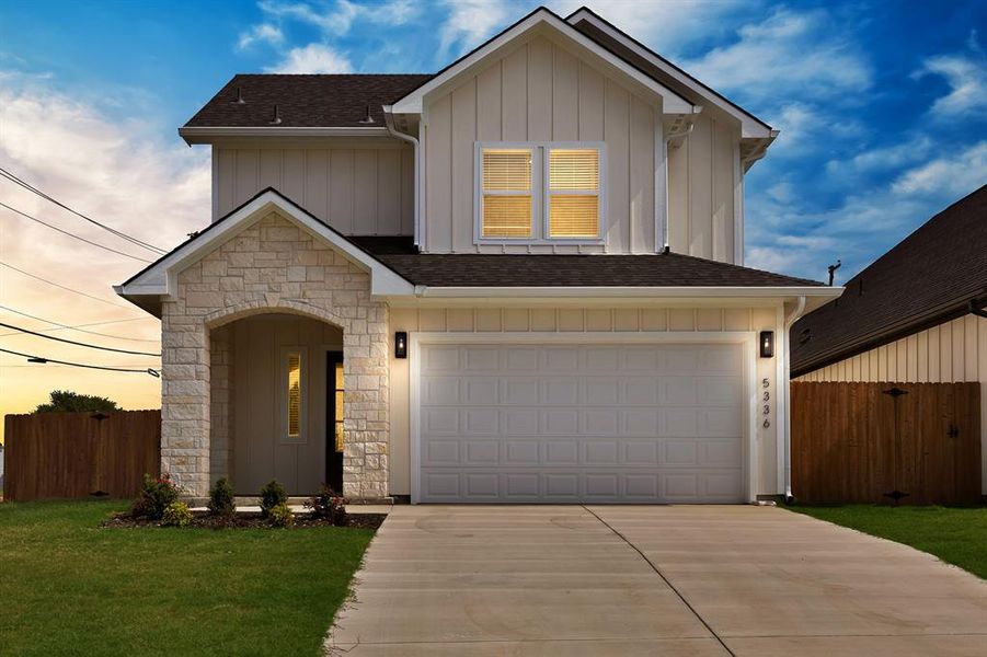 View of front of home with driveway, board and batten siding, stone siding, and a garage View of front of home with driveway, board and batten siding, stone siding, and a garage