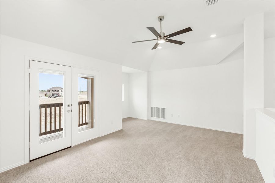 Empty room with carpet, ceiling fan, vaulted ceiling, and French doors leading to a balcony Empty room with carpet, ceiling fan, vaulted ceiling, and French doors leading to a balcony