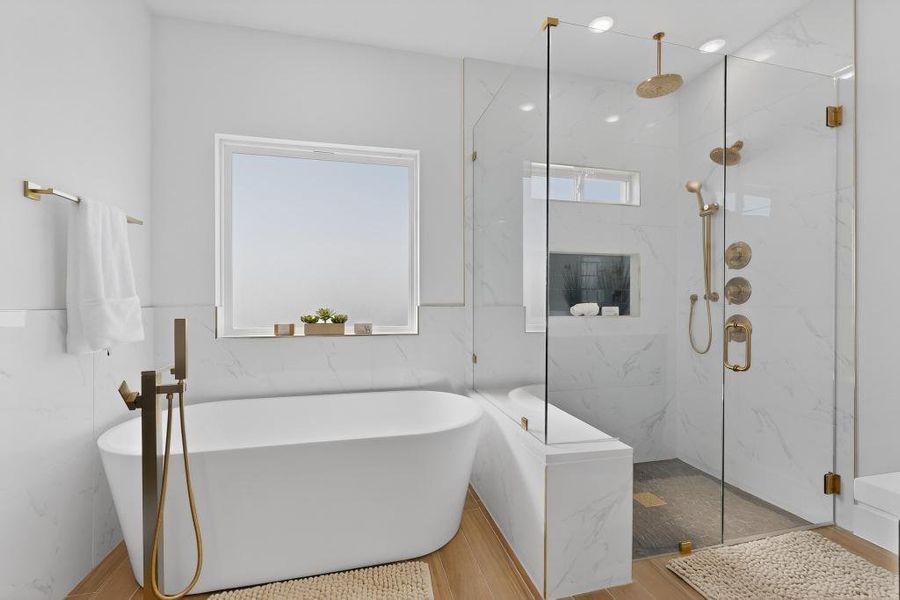 Primary Full bathroom featuring a marble finish shower, a freestanding tub, tile walls, and wood finished floors
