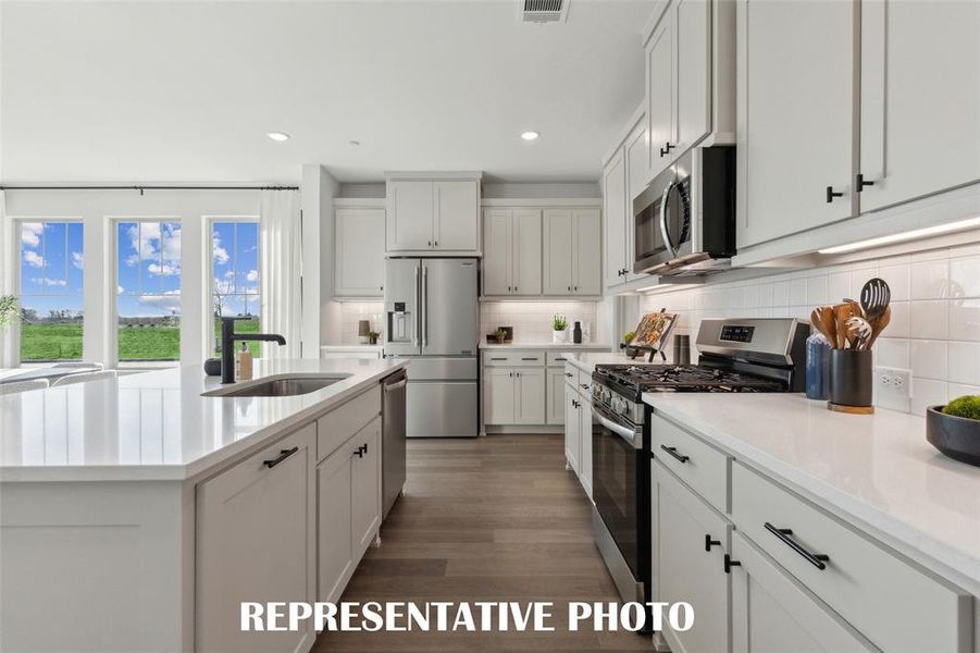 A stylish backsplash, stainless appliances, pot & pan drawers and so much more can be found in this over the top kitchen!  REPRESENTATIVE PHOTO