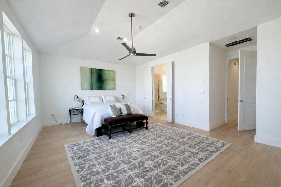 Vaulted ceilings in the primary bedroom!   Photo is virtually enhanced.