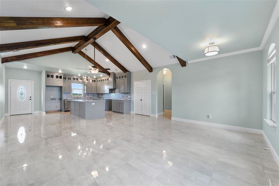 Kitchen with beamed ceiling, tasteful backsplash, pendant lighting, light tile patterned floors, and a kitchen island