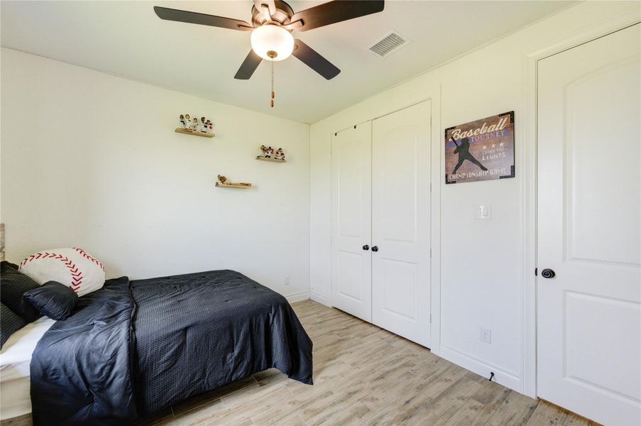 Comfortable bedroom with ceiling fan and generous closet space