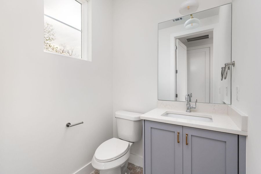 Half bath featuring vanity and toilet