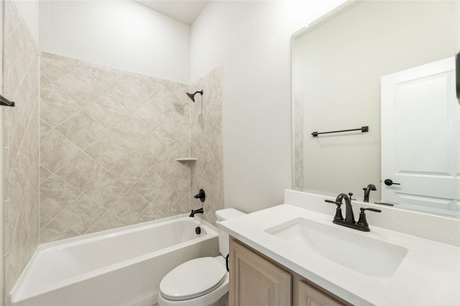 Full bathroom with tub-shower combo, diagonal tile surround, white vanity, and dark bronze fixtures Full bathroom with tub-shower combo, diagonal tile surround, white vanity, and dark bronze fixtures