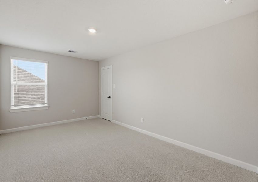 Secondary bedroom featuring a window and carpet flooring.