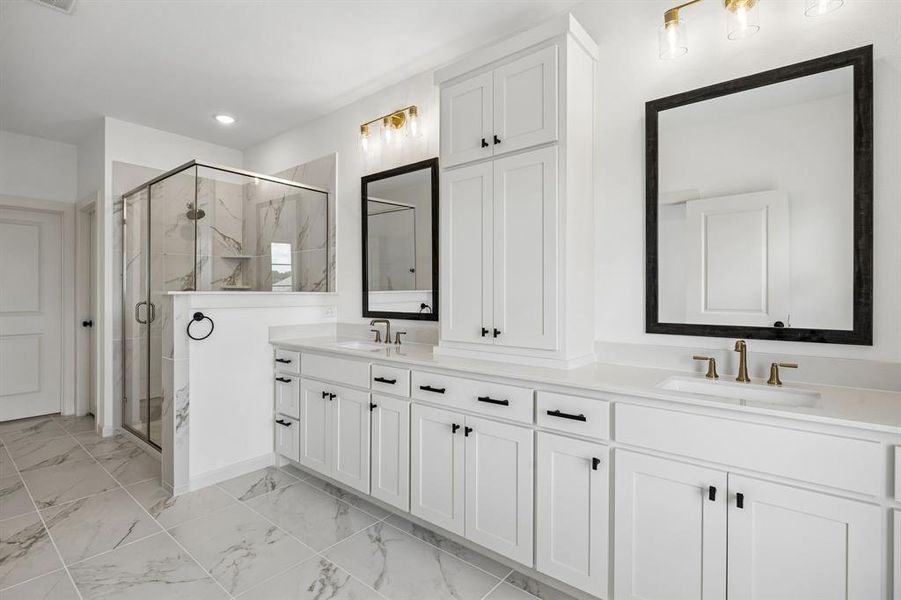With a spacious walk in shower, double vanity and classic black and white color palette, this owner's bath is a dream com true!