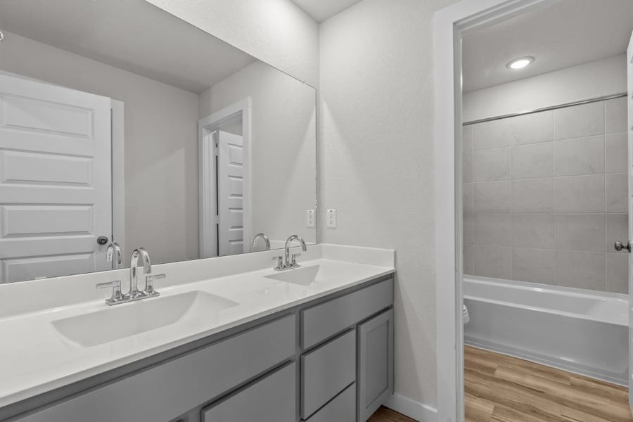 A bathroom with a sink and a mirror. A bathroom with a sink and a mirror.