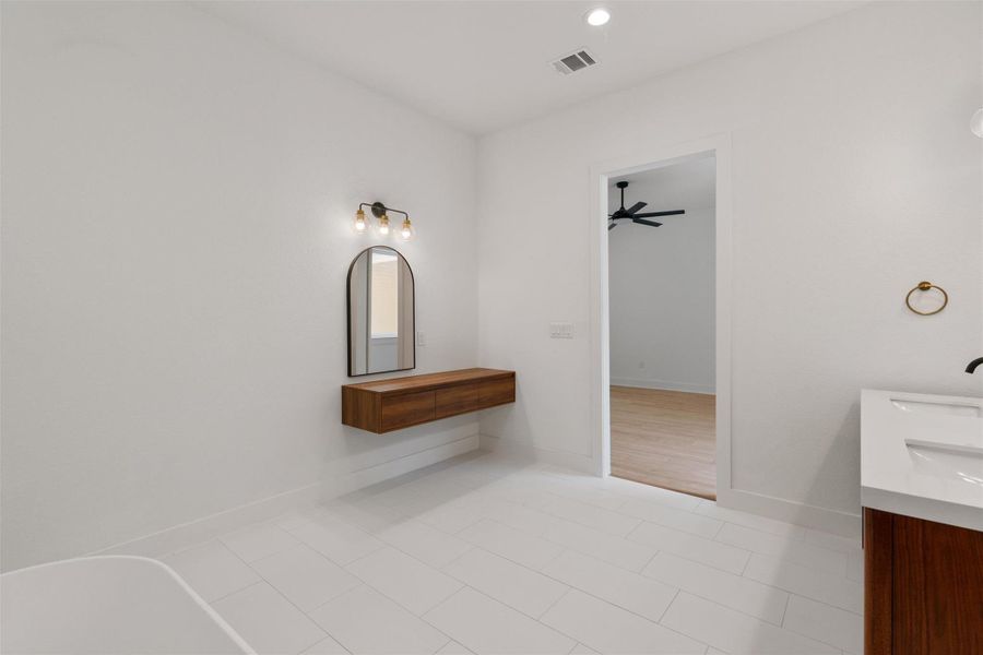 A well-lit, contemporary bathroom with sleek tiling and a minimalist vanity provides a serene atmosphere.