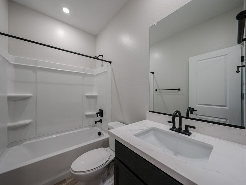 A bathroom with a tub sink and toilet.