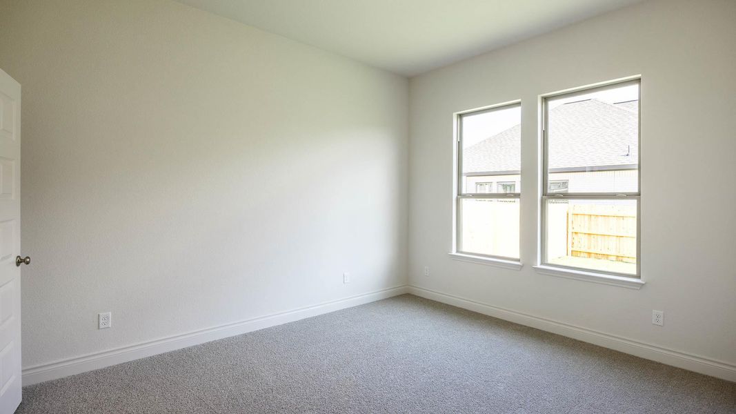 Carpeted spare room featuring baseboards Carpeted spare room featuring baseboards