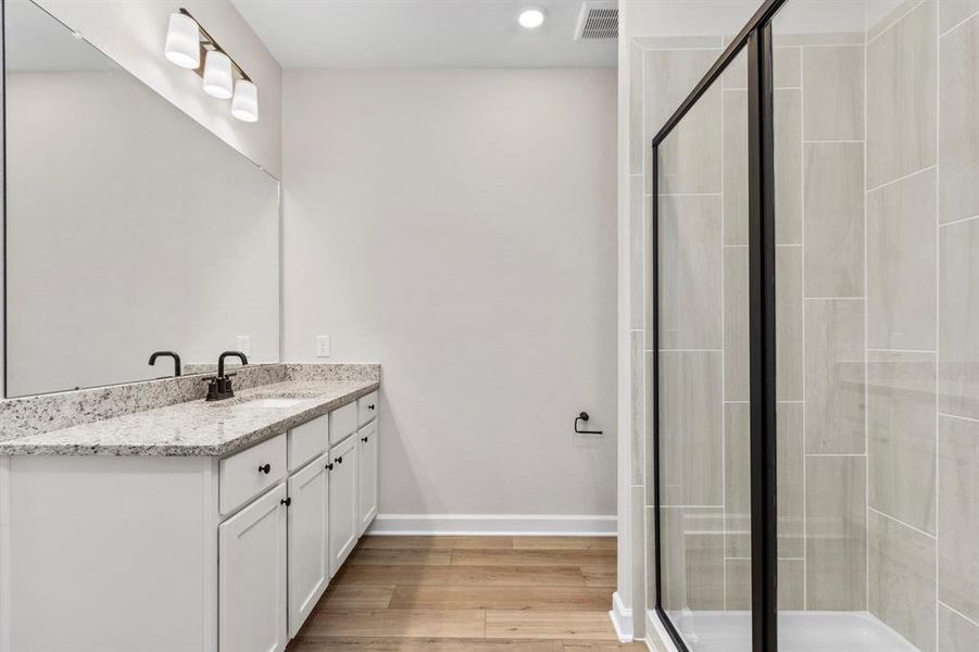 The primary bathroom has a large, standing shower with a gorgeous backsplash.