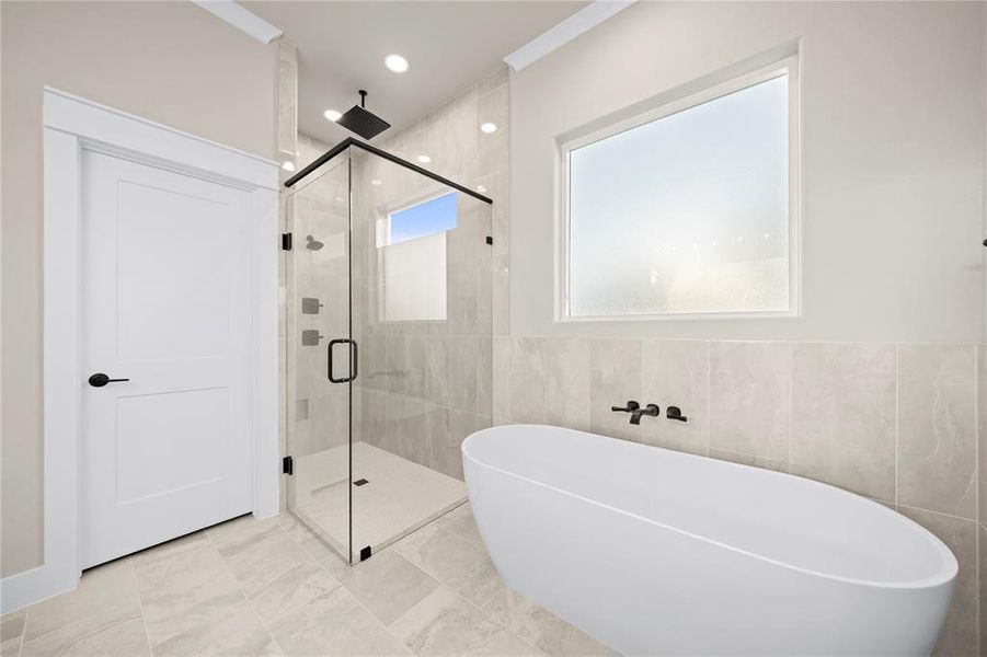 Bathroom with a stall shower, a soaking tub, tile walls, and recessed lighting