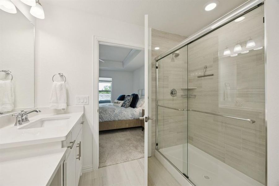 The bathroom offers oversized, walk-in shower with tile surround.