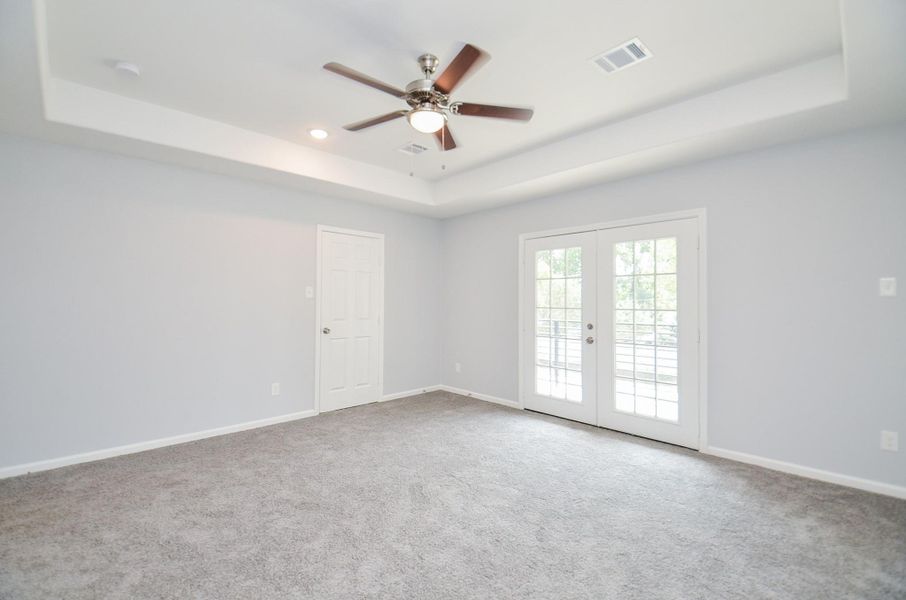 Spacious primary suite with calm vibes—room for a king bed, seating, and nightstands.