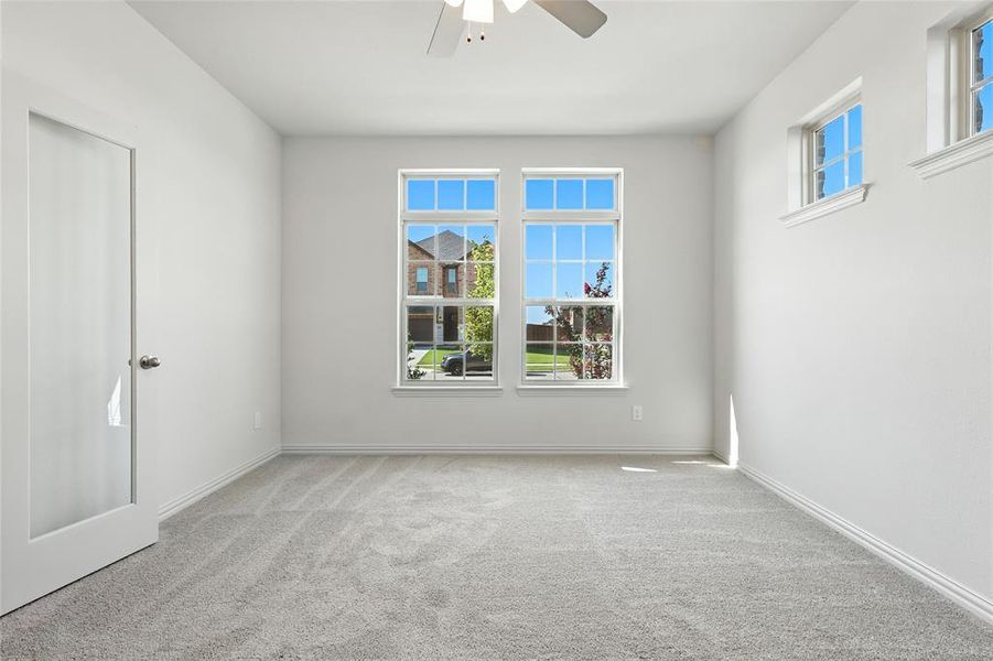 Unfurnished room featuring light carpet and a ceiling fan Unfurnished room featuring light carpet and a ceiling fan
