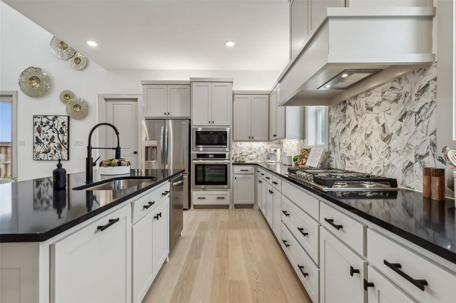 Beautiful cabinetry, gorgeous countertops, luxurious flooring and designer backsplash effortlessly pair with contemporary stainless steel to create a kitchen for the ages!