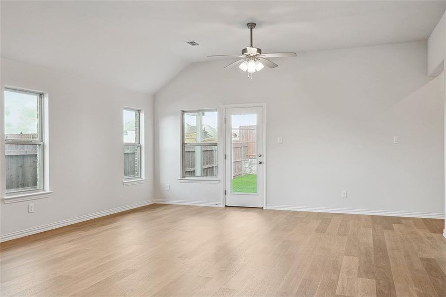 Unfurnished room with light hardwood / wood-style floors, lofted ceiling, and ceiling fan