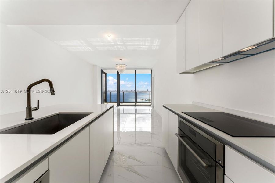 Modern chef’s kitchen equipped with custom Italian cabinetry, premium Miele appliances, integrated stone countertops, and a waterfall island perfect for entertaining.