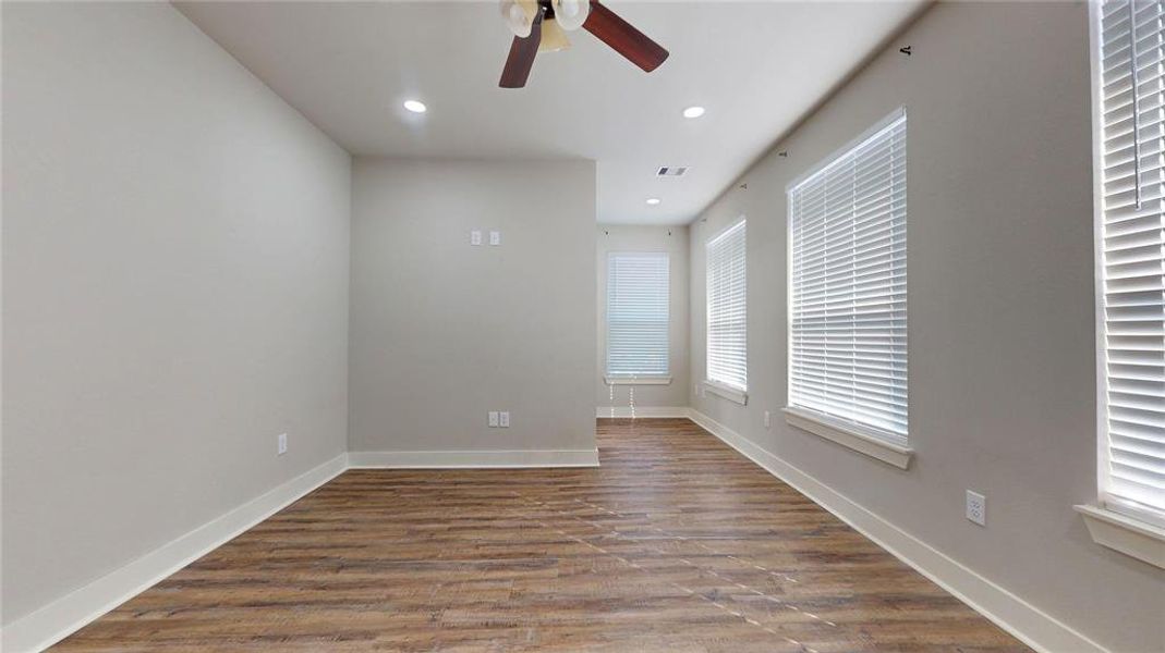 The primary suite faces the backyard and is flooded with natural light from several windows on two sides.