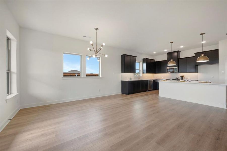 Kitchen with light countertops, a chandelier, plenty of natural light, and open floor plan Kitchen with light countertops, a chandelier, plenty of natural light, and open floor plan