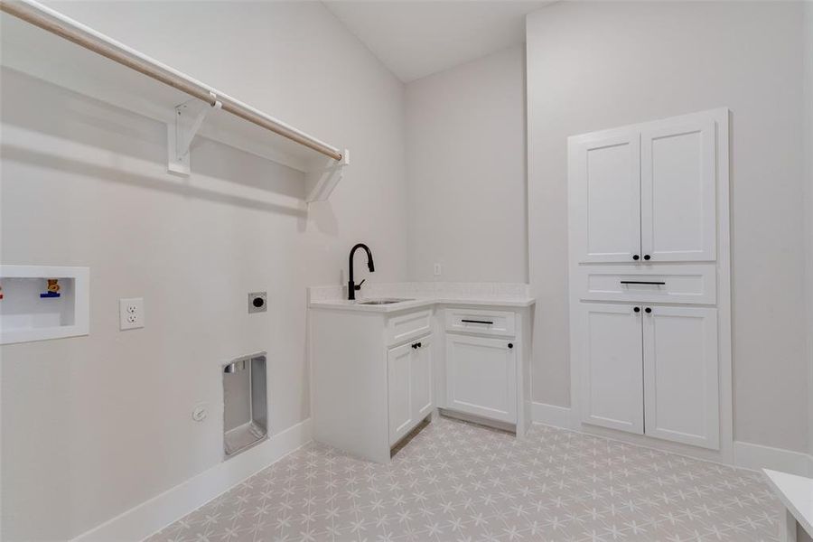 Washroom featuring gas dryer hookup, hookup for a washing machine, light tile flooring, electric dryer hookup, and sink