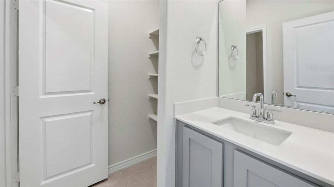 Bathroom featuring vanity, a closet, and light tile patterned floors Bathroom featuring vanity, a closet, and light tile patterned floors