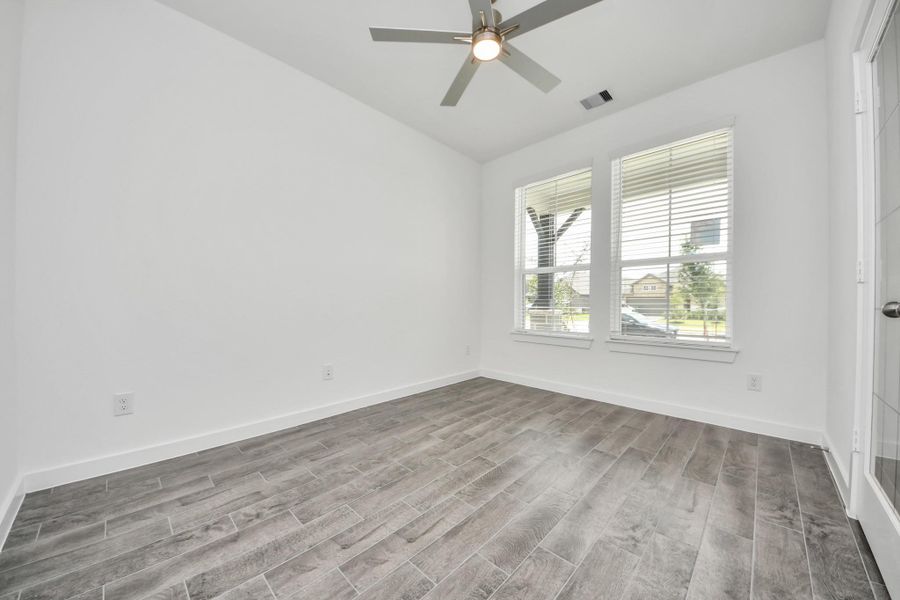 Step into the inviting home office, where elegant tile flooring adds a touch of freshness and comfort to the workspace. Natural light pours through the window, creating an inspiring environment for productivity and focus. Sample photo of completed home with similar floor plan. Actual colors and selections may vary.