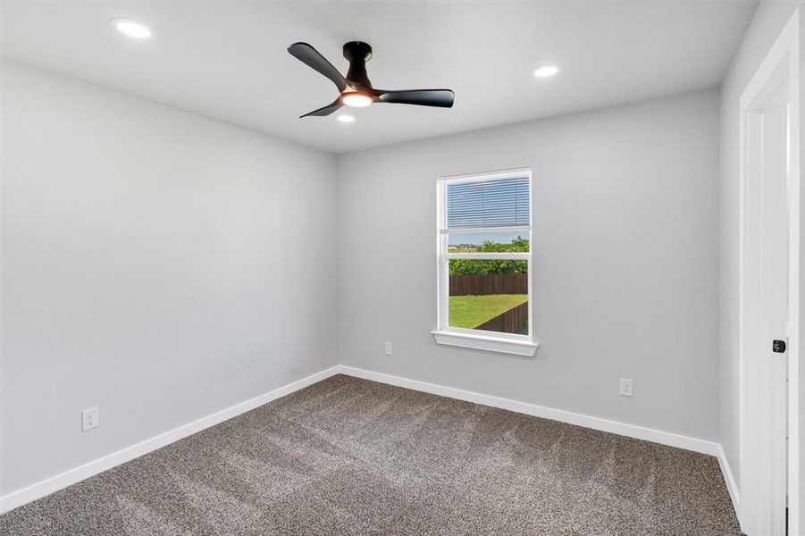 Unfurnished room with dark colored carpet, a ceiling fan, recessed lighting, and baseboards
