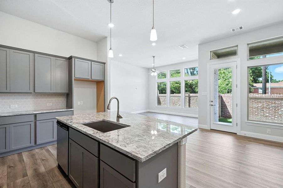 Kitchen with gray cabinets, wood finished floors, a ceiling fan, and recessed lighting Kitchen with gray cabinets, wood finished floors, a ceiling fan, and recessed lighting