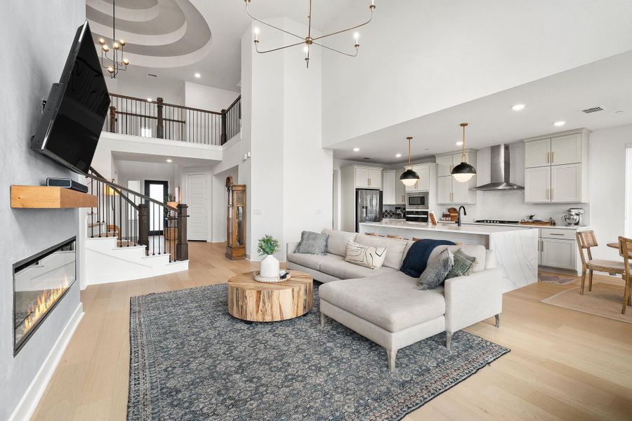 Open-concept living space featuring high ceilings and wood-finish flooring Open-concept living space featuring high ceilings and wood-finish flooring