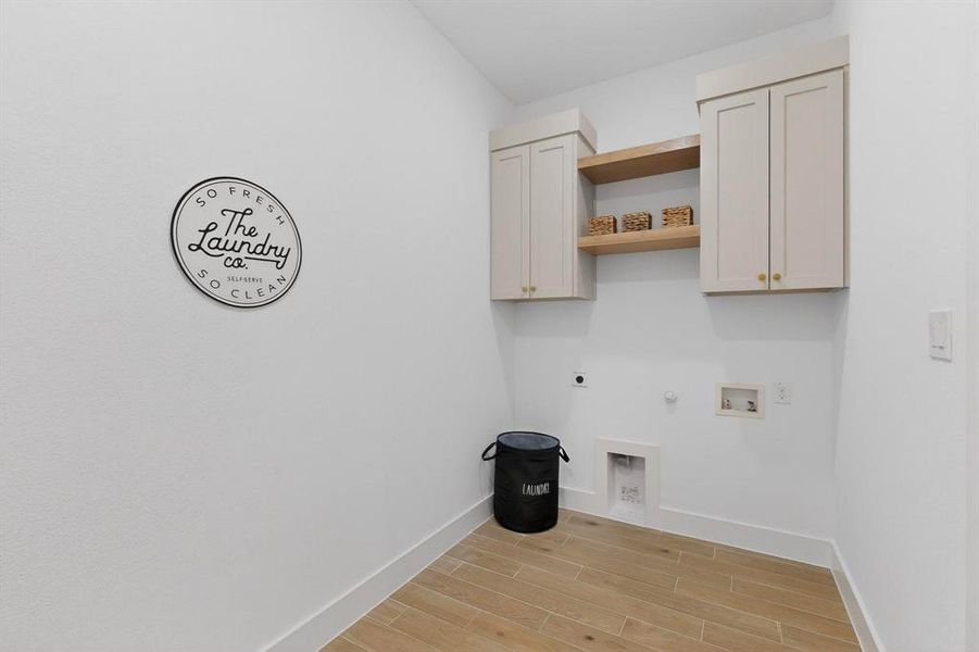 Laundry room featuring hookup for a gas dryer, wood tiled floors, hookup for an electric dryer, cabinet space, and hookup for a washing machine