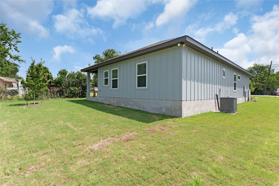 View of side of home featuring a lawn and board and batten siding