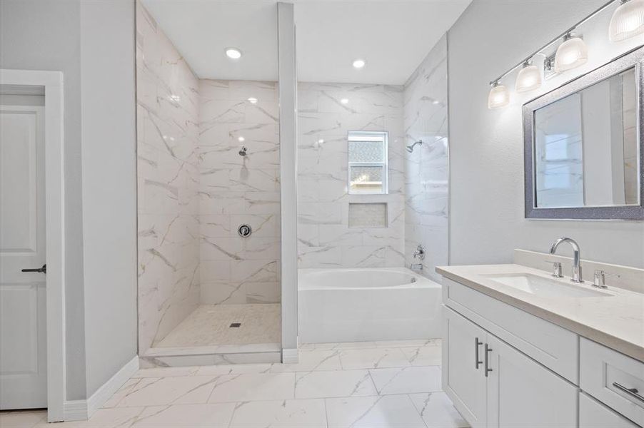 uxurious en-suite with a soaking tub, separate shower, and double sink vanity.