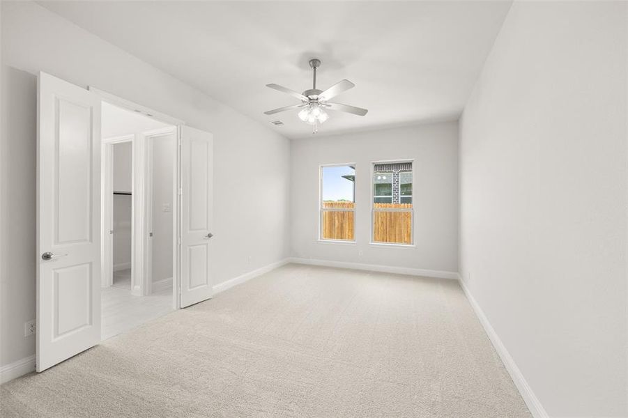 Empty room featuring carpet flooring and ceiling fan Empty room featuring carpet flooring and ceiling fan