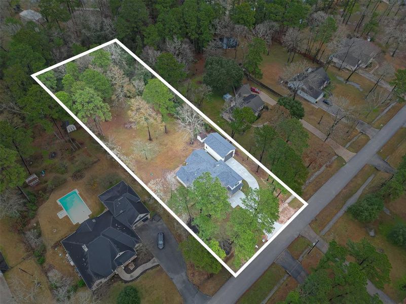 This aerial photo showcases a spacious, rectangular lot with mature trees.