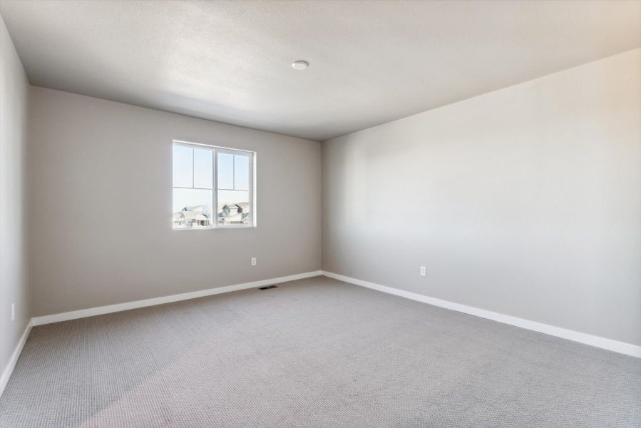A room with a window and a white wall.